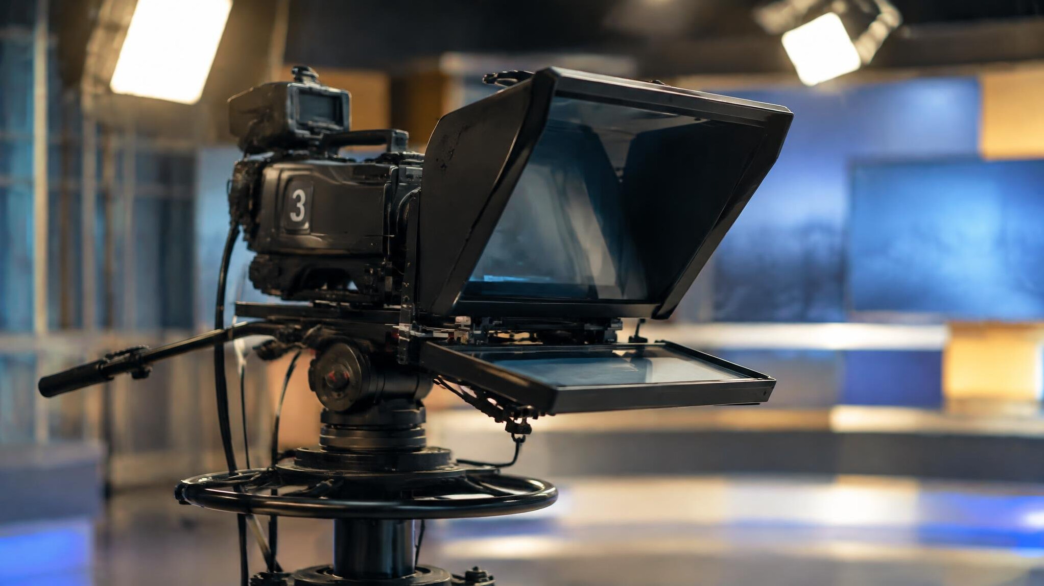 Studio television camera on a pedestal in a lit studio